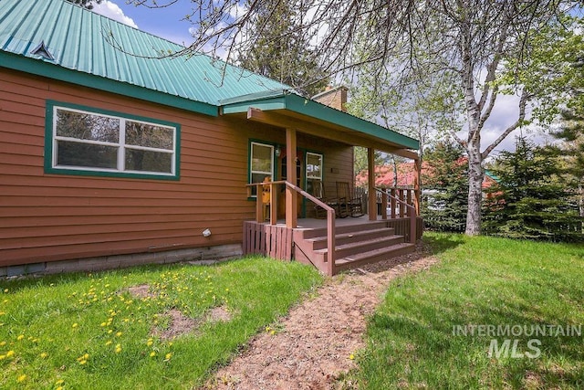 1102 Davis, Mccall, ID 83638 - view of front of property featuring metal roof, a front yard, a chimney, and a porch