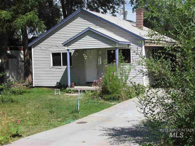 252 1st St N, Nampa, ID 83687 - bungalow featuring a front lawn, a porch, and a chimney