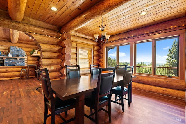 dining area with rustic walls, beamed ceiling, dark hardwood / wood-style floors, a notable chandelier, and wood ceiling