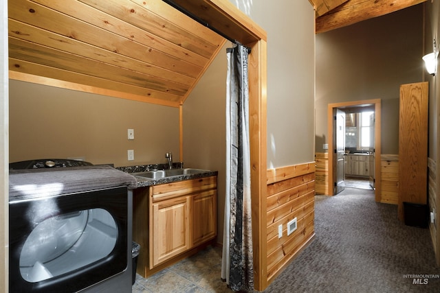 interior space with carpet, wood walls, sink, washer / dryer, and wood ceiling