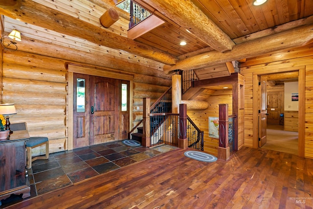 entrance foyer with beamed ceiling, dark hardwood / wood-style flooring, wood ceiling, and rustic walls