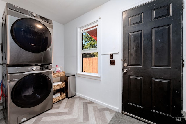 laundry room featuring baseboards, laundry area, and stacked washer / dryer