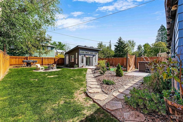 view of yard featuring a fenced backyard, a patio, and an outbuilding