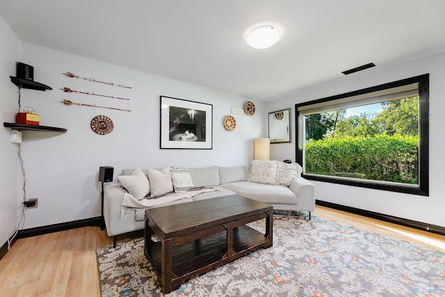 living room featuring baseboards, visible vents, and light wood-style floors
