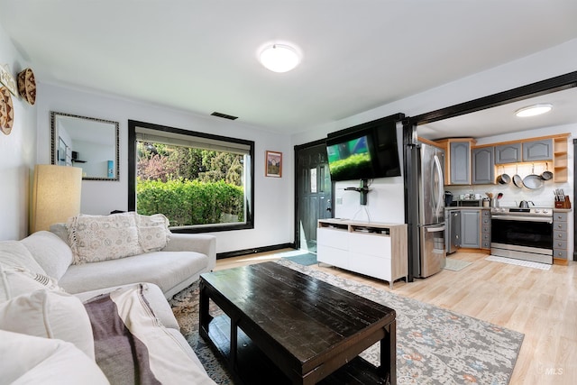 living room with visible vents and light wood-style flooring