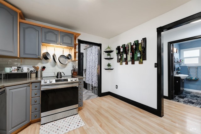 kitchen featuring gray cabinetry, appliances with stainless steel finishes, and light wood finished floors