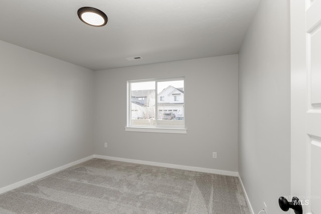 empty room featuring carpet floors, baseboards, and visible vents