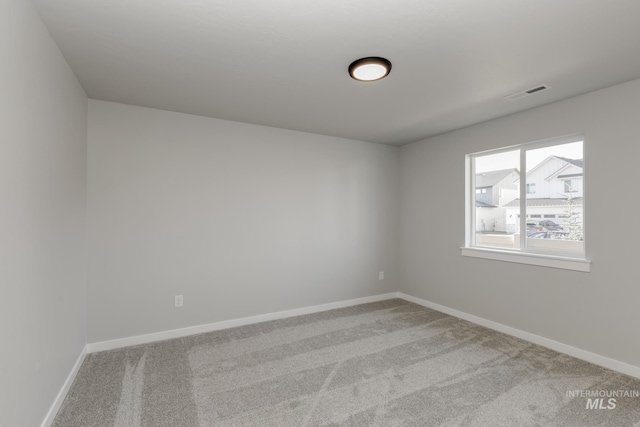 carpeted empty room featuring visible vents and baseboards