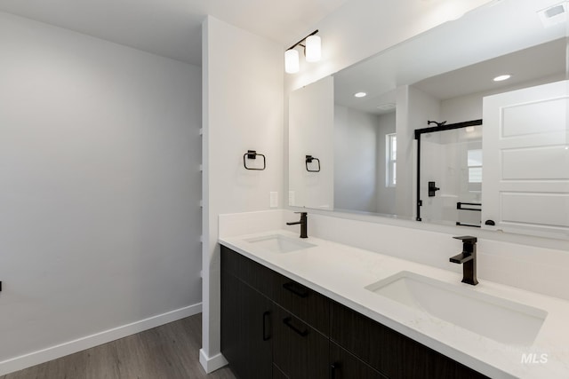 bathroom with vanity, a shower with shower door, and hardwood / wood-style floors