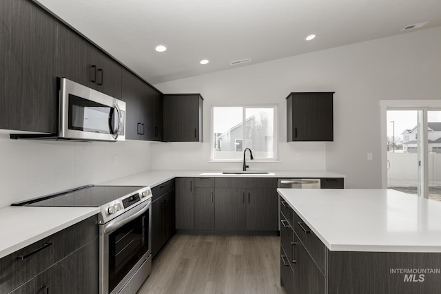 kitchen featuring light wood-style flooring, recessed lighting, a sink, light countertops, and appliances with stainless steel finishes