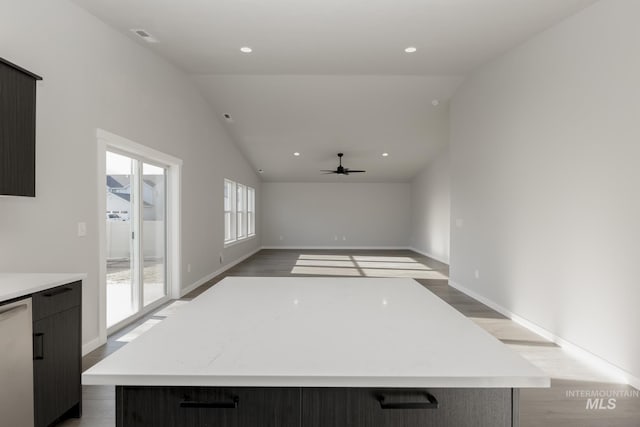 kitchen featuring a large island, vaulted ceiling, dishwasher, and light wood-type flooring