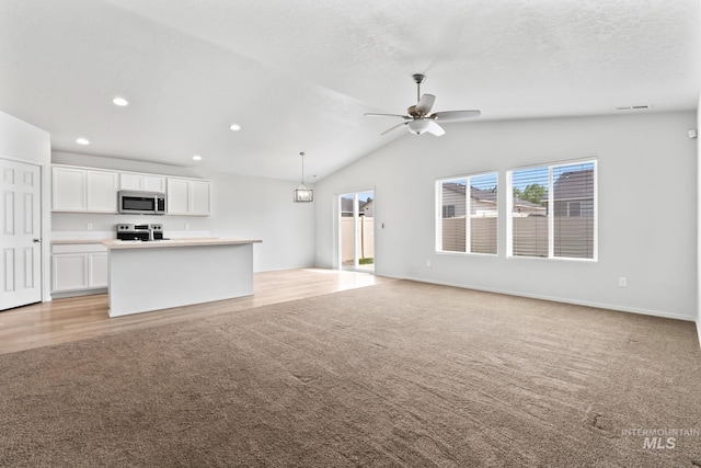 1773 E E Celbridge St, Nampa, ID 83686 - unfurnished living room with light colored carpet, ceiling fan, vaulted ceiling, and recessed lighting