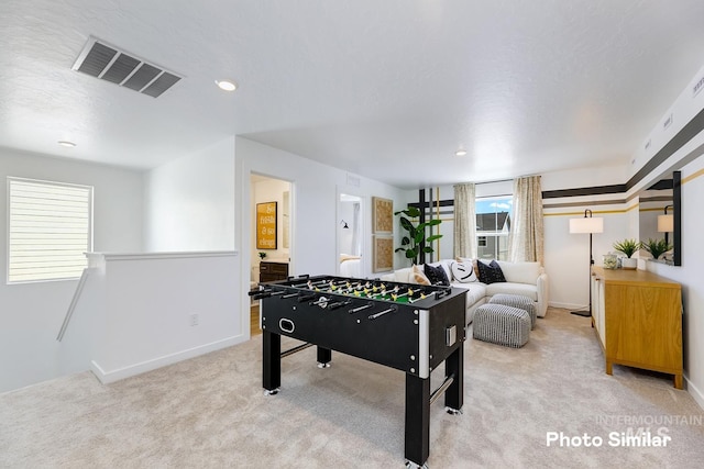 game room featuring light colored carpet and a textured ceiling