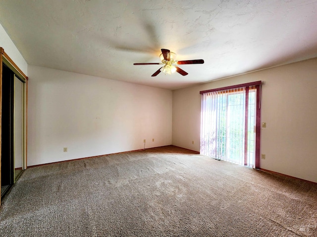 spare room featuring ceiling fan and carpet floors