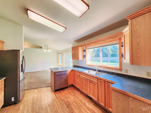 kitchen with sink, lofted ceiling, kitchen peninsula, light hardwood / wood-style flooring, and appliances with stainless steel finishes