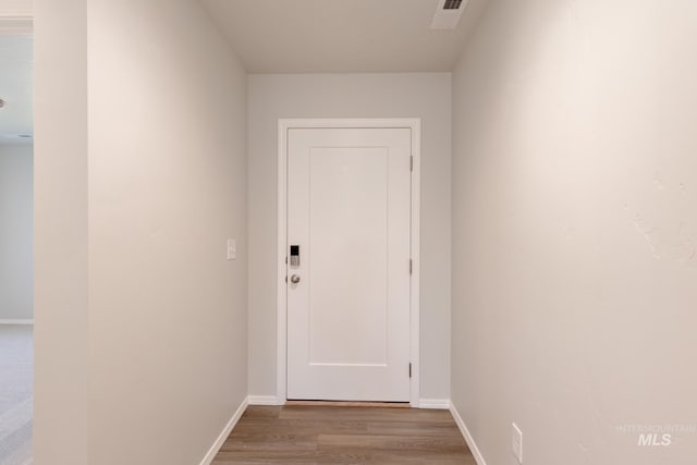 doorway to outside with visible vents, baseboards, and wood finished floors