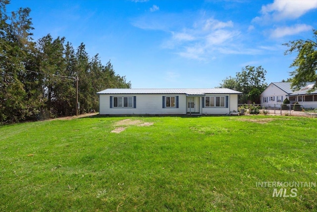 manufactured / mobile home featuring metal roof, fence, and a front lawn