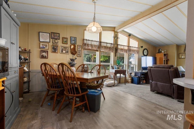 dining area featuring vaulted ceiling with beams and wood finished floors