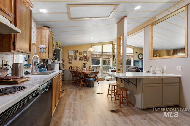 kitchen with light countertops, black dishwasher, a breakfast bar area, and vaulted ceiling