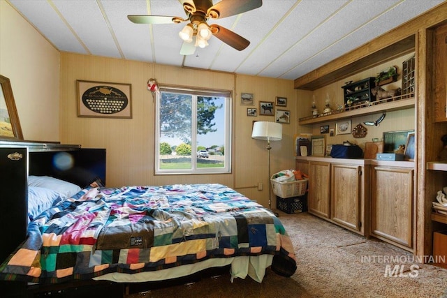 bedroom with wooden walls and carpet floors