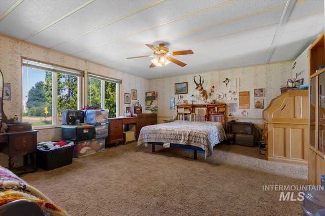 carpeted bedroom with wallpapered walls and a ceiling fan