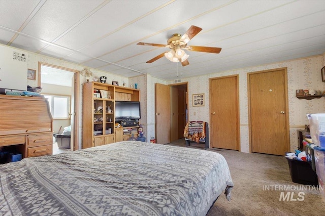 carpeted bedroom featuring a ceiling fan and wallpapered walls