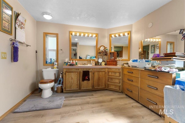 full bath featuring vanity, toilet, and wood finished floors