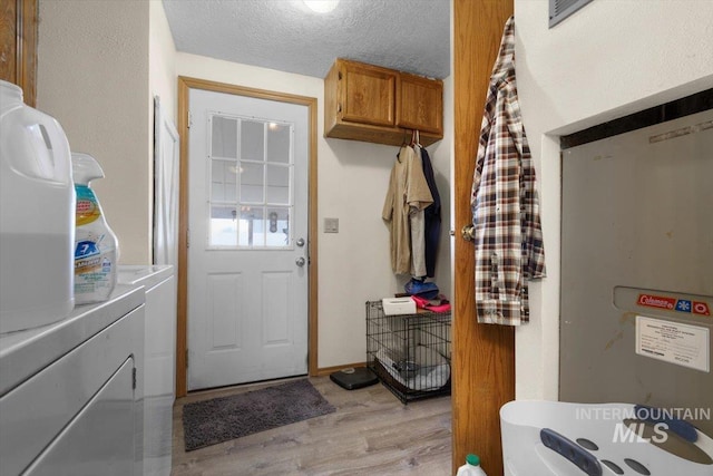 interior space with light wood-style floors, a textured ceiling, and separate washer and dryer