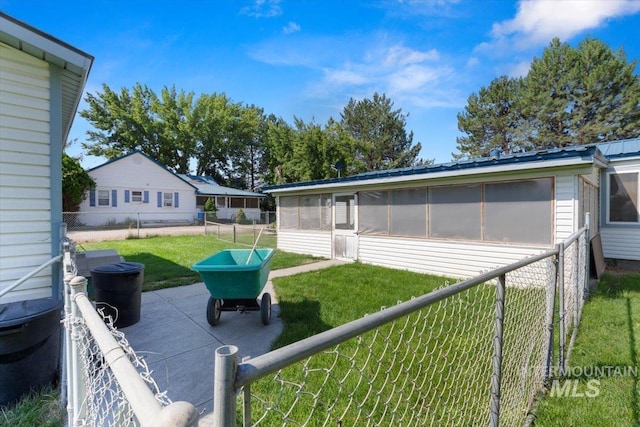 view of yard featuring a sunroom, a fenced backyard, and a patio area