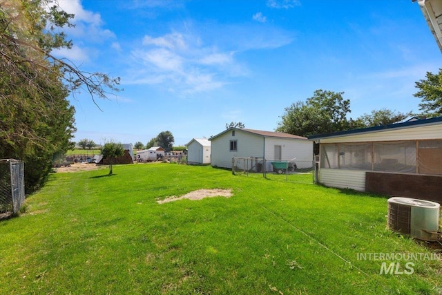 view of yard featuring a sunroom, central AC, and fence