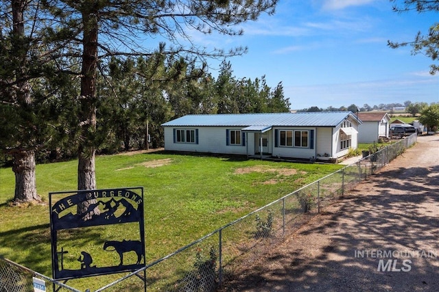 view of front of home with a front yard, metal roof, and fence private yard