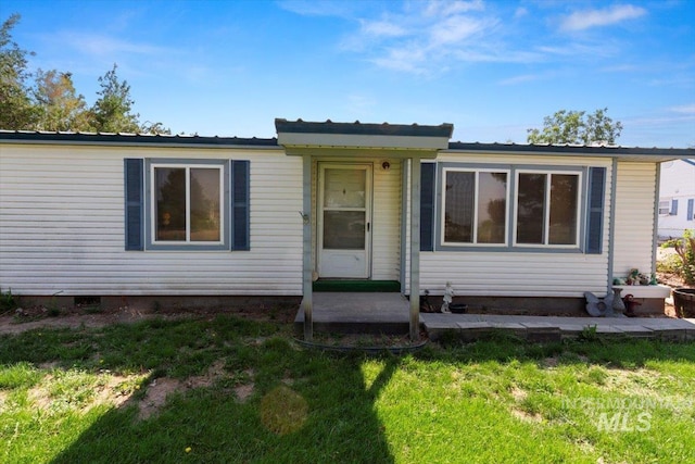 view of front of home featuring metal roof and a front yard