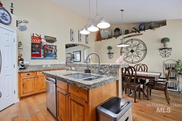 kitchen featuring light hardwood / wood-style floors, a center island with sink, pendant lighting, sink, and dishwasher