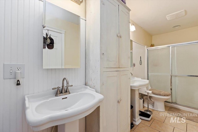 bathroom with sink, tile flooring, a shower with shower door, and toilet