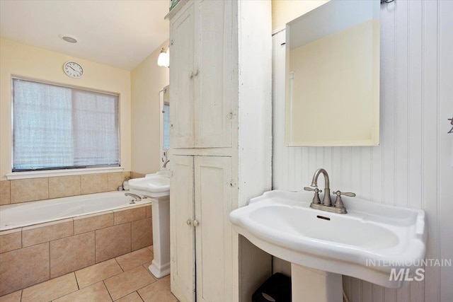 bathroom featuring sink, tile flooring, and tiled tub