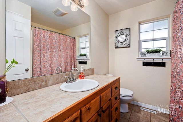 bathroom featuring tile flooring, vanity, and toilet