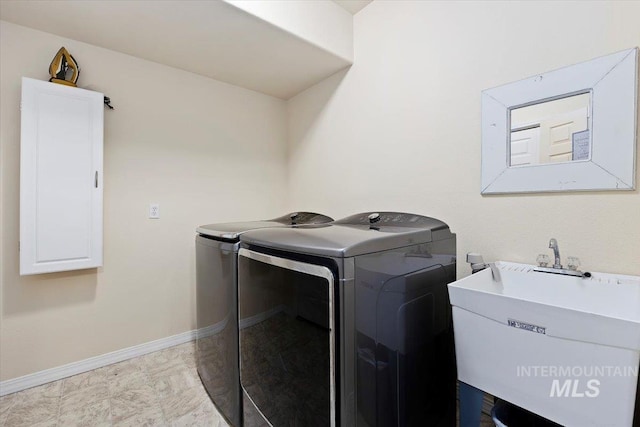 laundry area featuring separate washer and dryer, sink, and light tile floors