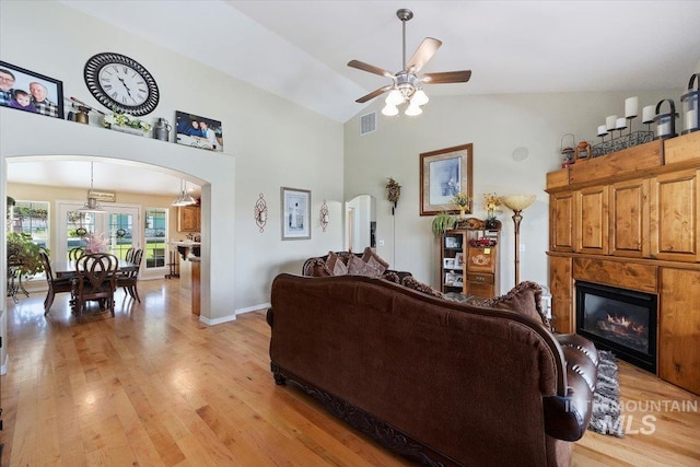 living room featuring high vaulted ceiling, light wood-type flooring, and ceiling fan