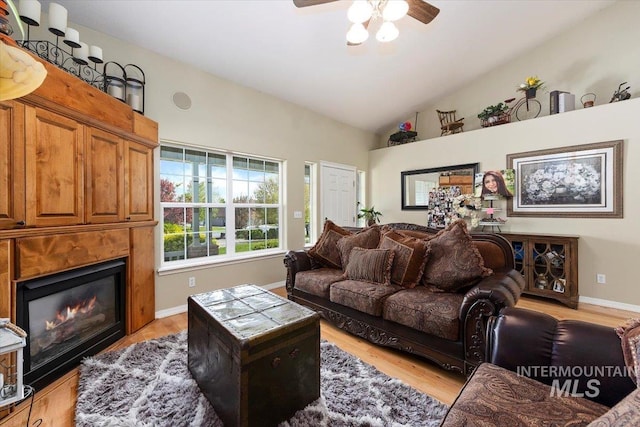 living room with ceiling fan, light wood-type flooring, and lofted ceiling