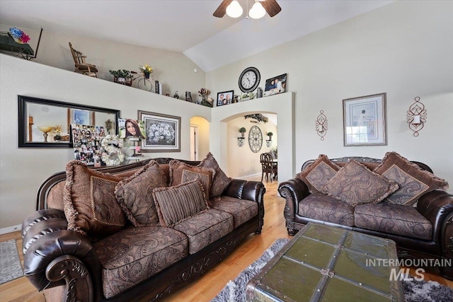 living room with high vaulted ceiling, ceiling fan, and light hardwood / wood-style flooring