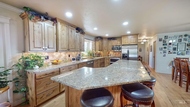 kitchen with appliances with stainless steel finishes, a center island, a sink, and backsplash