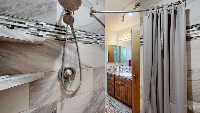 full bath with a tile shower and vanity