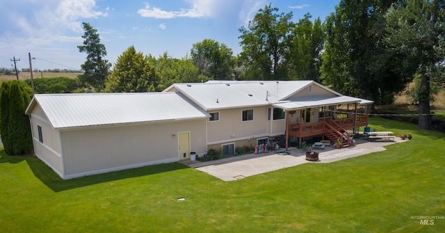 rear view of property with a patio, a lawn, an outdoor fire pit, metal roof, and stairs