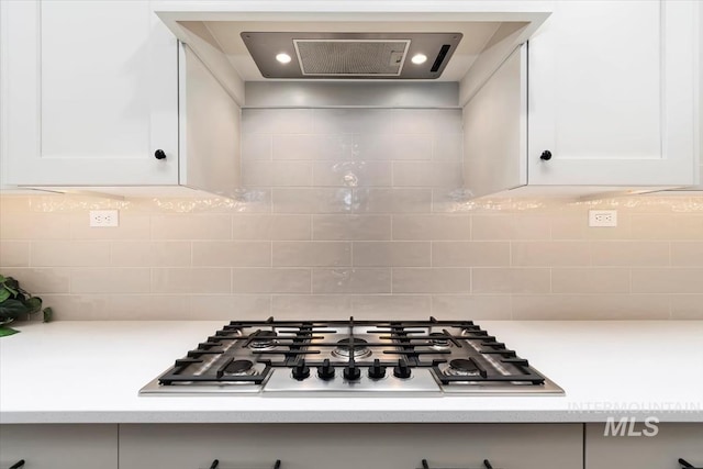 kitchen featuring backsplash, white cabinets, extractor fan, and stainless steel gas stovetop