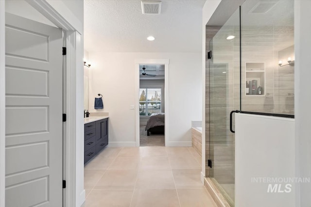 bathroom featuring tile patterned floors, an enclosed shower, a textured ceiling, vanity, and ceiling fan