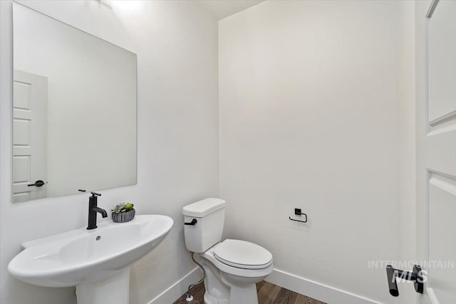 bathroom featuring hardwood / wood-style flooring, toilet, and sink