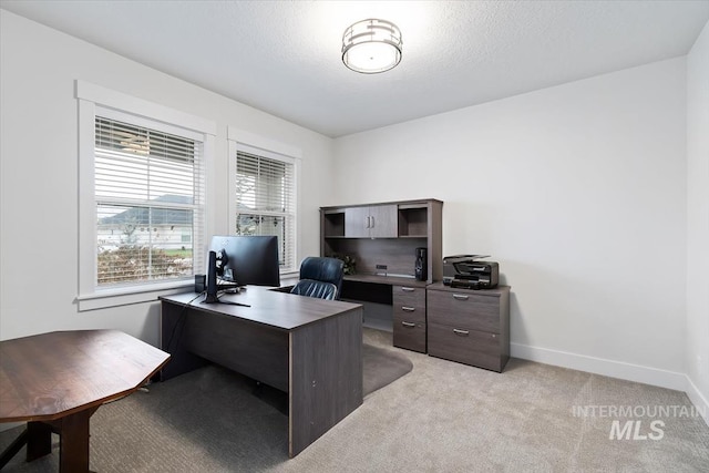 home office featuring light colored carpet and a textured ceiling