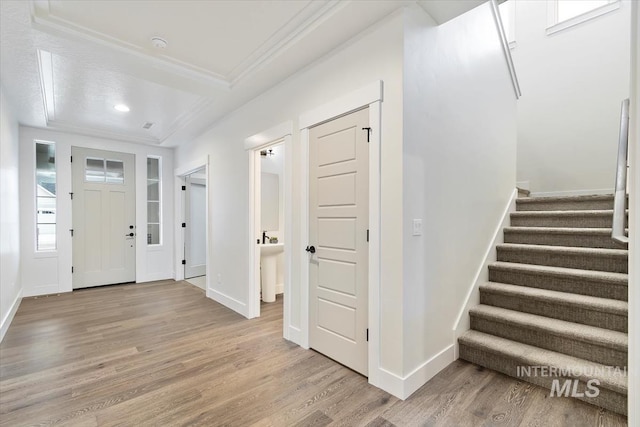 entrance foyer featuring crown molding and light hardwood / wood-style flooring