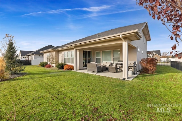 rear view of property featuring a lawn, an outdoor living space, and a patio