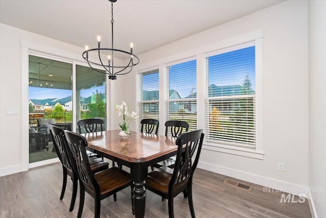 dining space with a notable chandelier and dark wood-type flooring